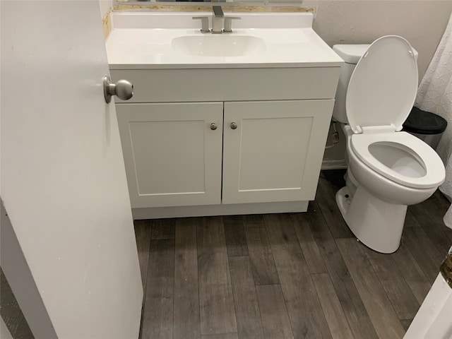 bathroom with vanity, toilet, and wood-type flooring