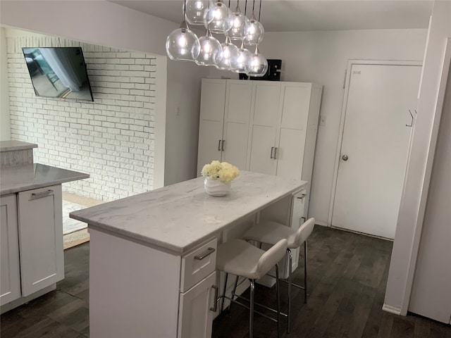 kitchen with white cabinetry, a center island, dark wood-type flooring, and pendant lighting