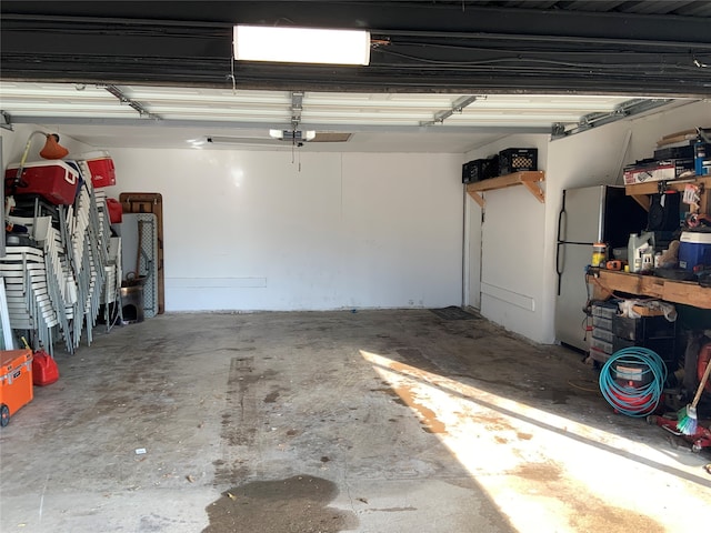 garage with a garage door opener and stainless steel refrigerator