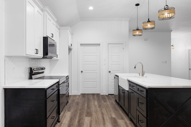 kitchen with hanging light fixtures, stainless steel appliances, crown molding, lofted ceiling, and white cabinets