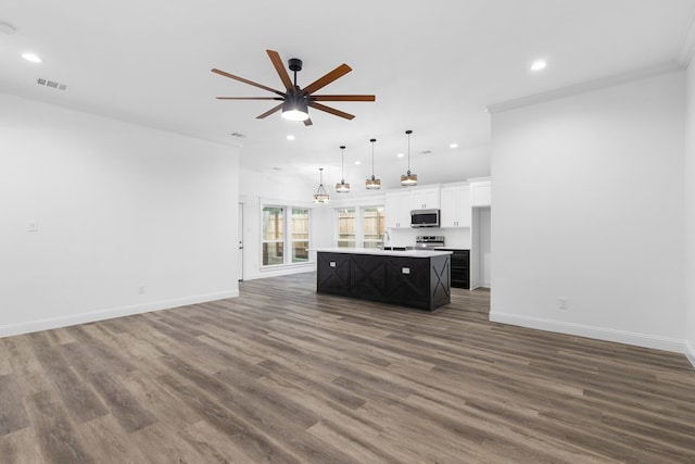 unfurnished living room featuring ceiling fan, dark hardwood / wood-style flooring, ornamental molding, and sink