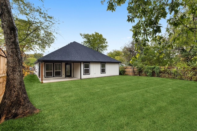 back of house with a yard and a patio