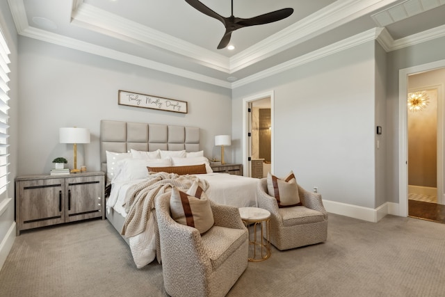 carpeted bedroom featuring a raised ceiling, connected bathroom, ceiling fan, and ornamental molding