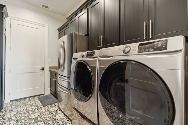 clothes washing area with cabinets, separate washer and dryer, and ornamental molding