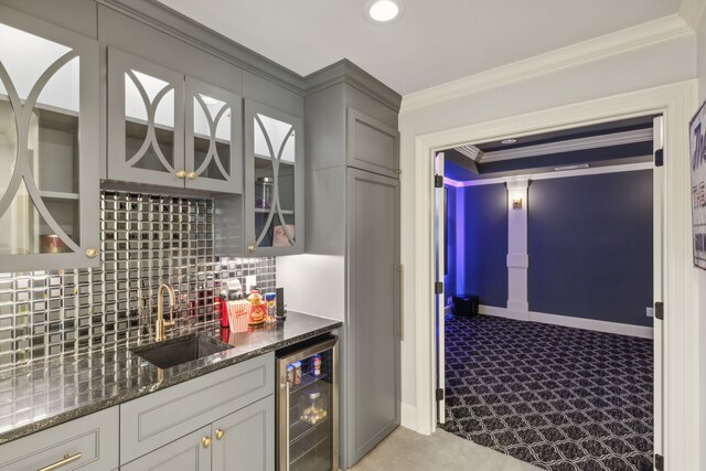 bar featuring gray cabinetry, light carpet, sink, ornamental molding, and beverage cooler