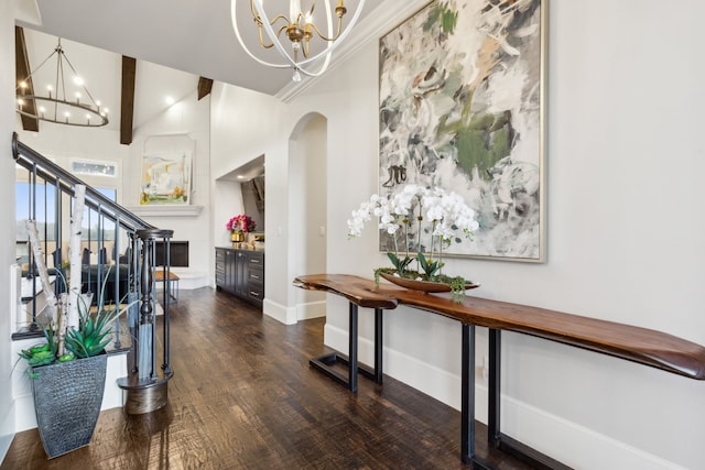 entryway with a chandelier, high vaulted ceiling, and dark wood-type flooring