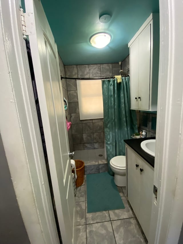 bathroom with curtained shower, tile patterned flooring, vanity, and toilet