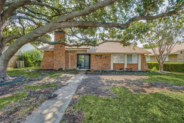 ranch-style home with a front yard and central AC unit