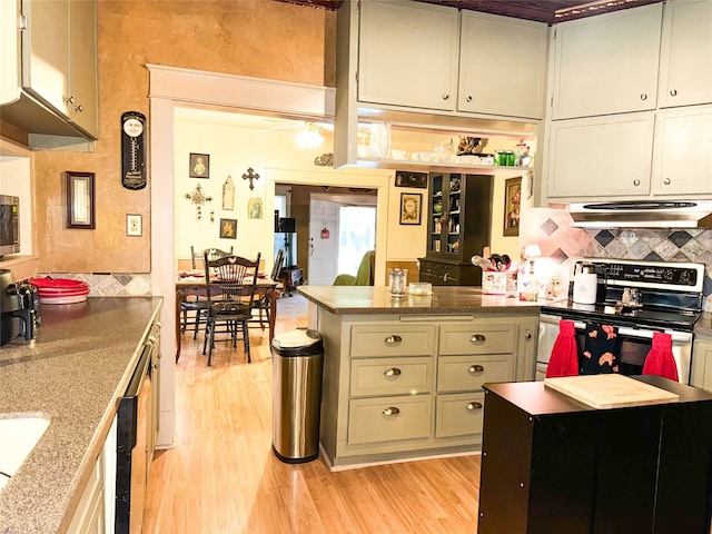 kitchen with stainless steel range with electric stovetop, extractor fan, stone countertops, decorative backsplash, and light wood-type flooring