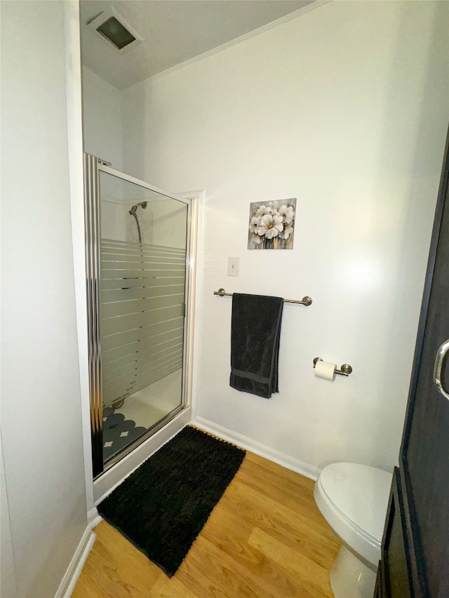 bathroom featuring an enclosed shower, hardwood / wood-style floors, and toilet