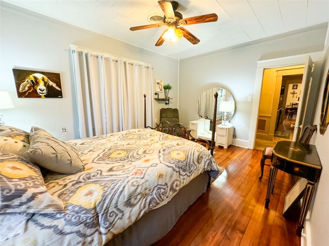 bedroom featuring wood-type flooring, ornamental molding, and ceiling fan