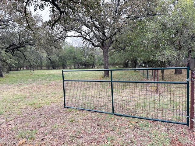 view of gate with a yard