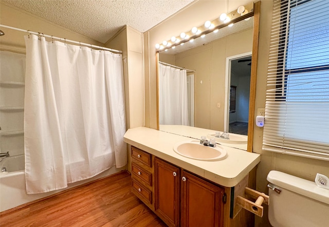 full bathroom featuring shower / bathtub combination with curtain, vanity, wood-type flooring, a textured ceiling, and toilet