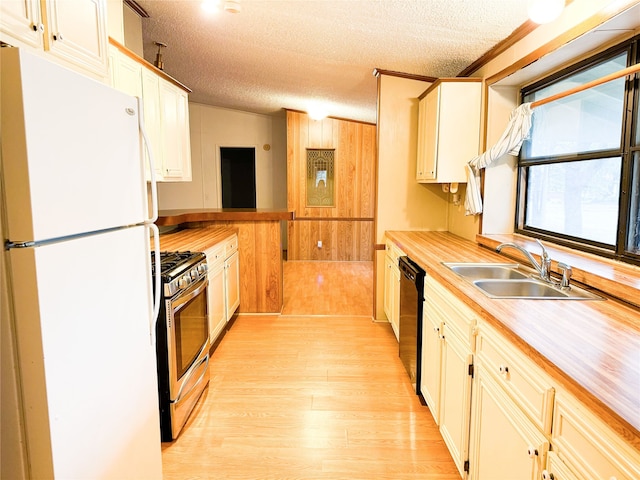 kitchen featuring stainless steel gas range, sink, light hardwood / wood-style flooring, dishwasher, and white fridge