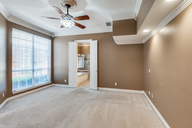 carpeted empty room with ornamental molding, a healthy amount of sunlight, and ceiling fan