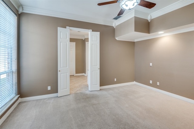 carpeted spare room with ceiling fan and ornamental molding