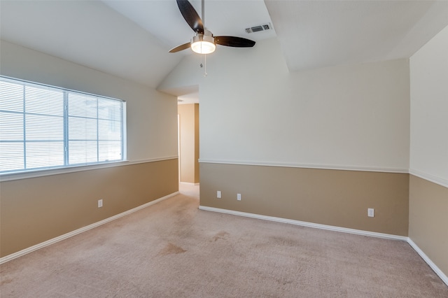 empty room featuring lofted ceiling, light colored carpet, and ceiling fan