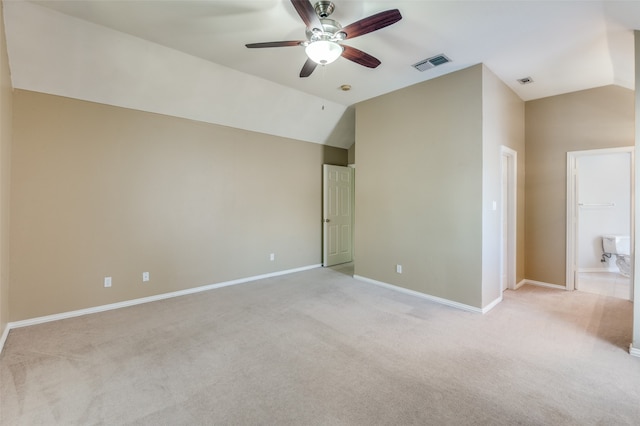 unfurnished bedroom with light carpet, ceiling fan, ensuite bath, and vaulted ceiling