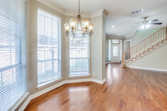 unfurnished dining area with ornamental molding, hardwood / wood-style flooring, ceiling fan with notable chandelier, and plenty of natural light