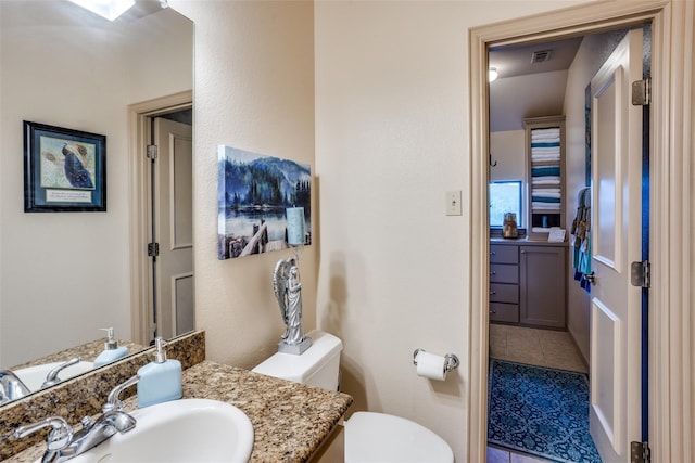 bathroom featuring tile patterned floors, vanity, and toilet