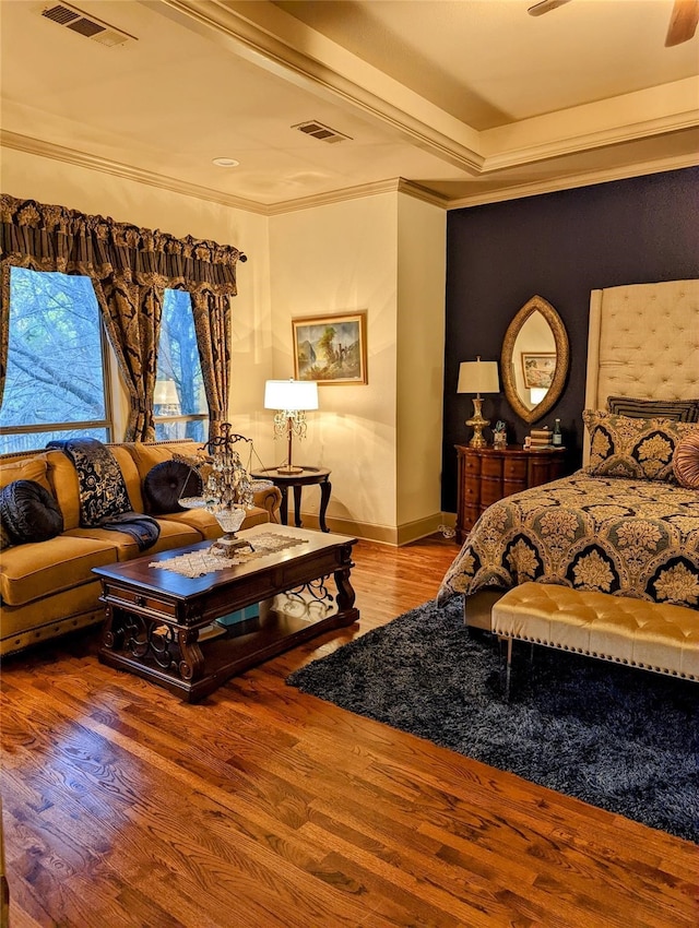 bedroom with hardwood / wood-style floors, ceiling fan, and crown molding