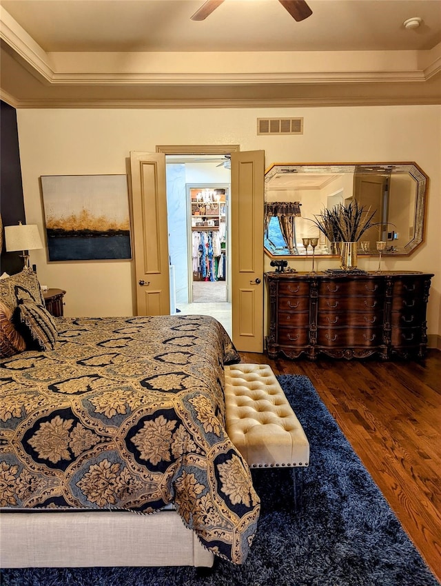 bedroom featuring dark hardwood / wood-style flooring, ceiling fan, and crown molding