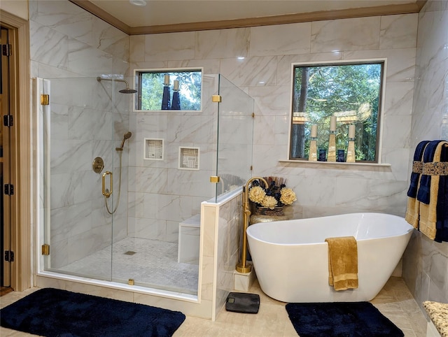 bathroom with tile walls, tile patterned flooring, a healthy amount of sunlight, and independent shower and bath