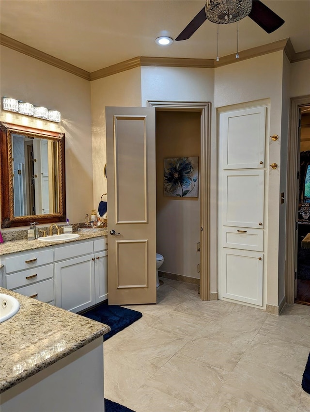 bathroom with ceiling fan, vanity, toilet, and ornamental molding