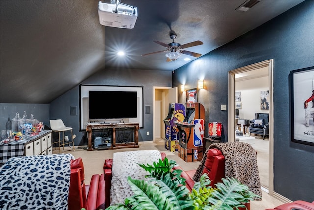 cinema featuring vaulted ceiling, light carpet, ceiling fan, and a textured ceiling