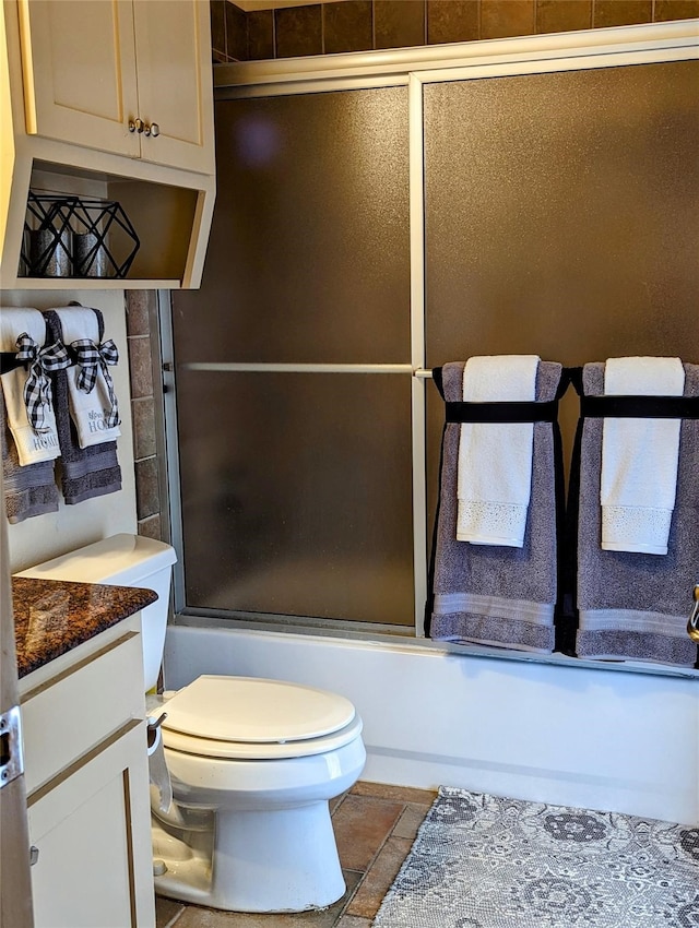 full bathroom featuring toilet, tile patterned floors, vanity, and enclosed tub / shower combo