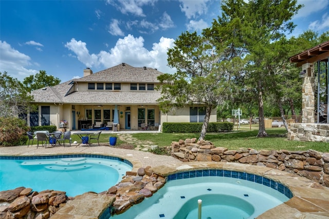 view of pool featuring a lawn, a patio, and an in ground hot tub