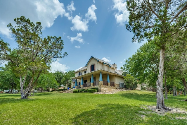 rear view of property with central air condition unit and a yard