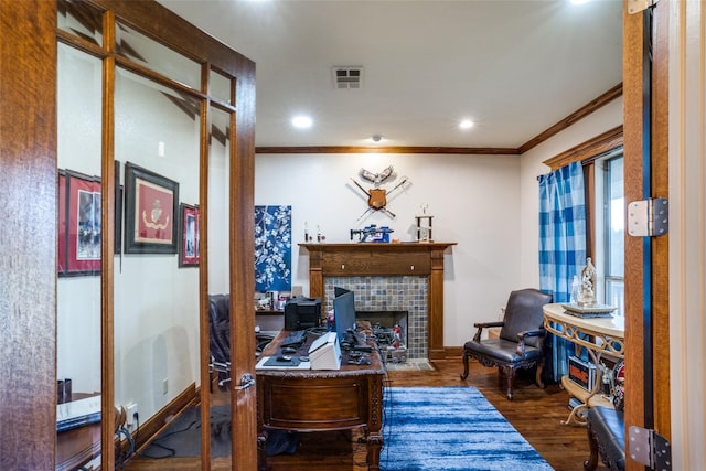 home office with wood-type flooring, crown molding, and a fireplace