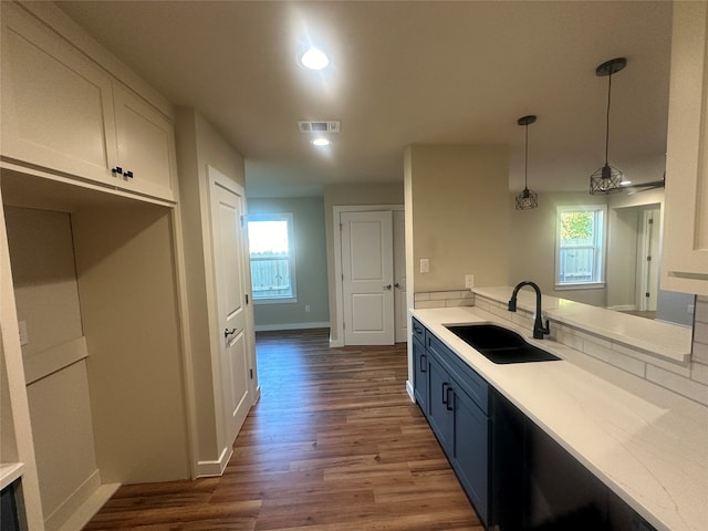 kitchen featuring hanging light fixtures, sink, white cabinets, dark wood-type flooring, and blue cabinets