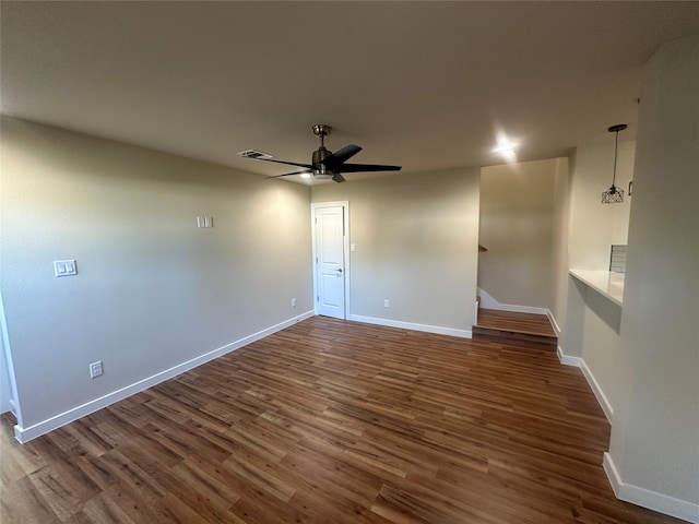 empty room with dark wood-type flooring and ceiling fan