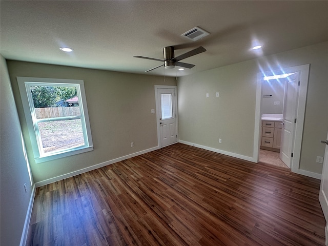 interior space featuring dark wood-type flooring, ceiling fan, and a textured ceiling