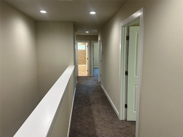 hall with dark colored carpet