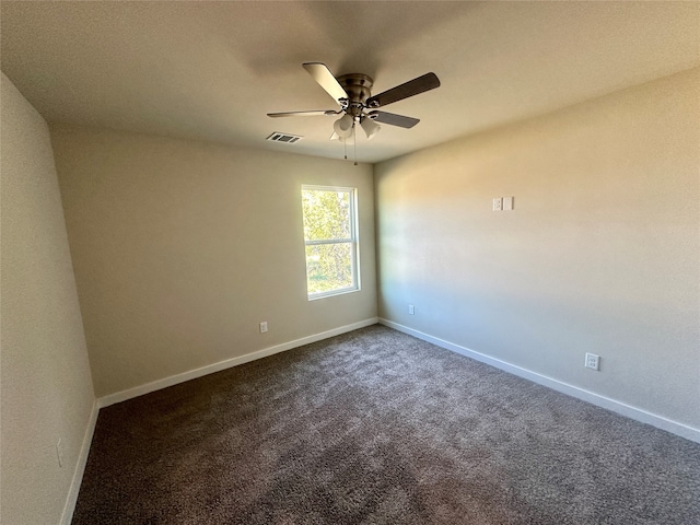 empty room with ceiling fan and dark carpet