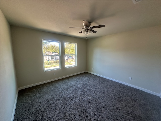 carpeted spare room featuring ceiling fan