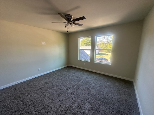 empty room featuring dark colored carpet and ceiling fan