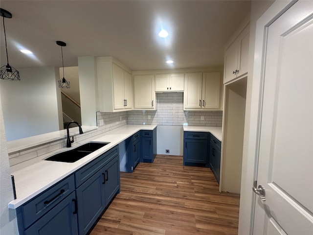 kitchen featuring hanging light fixtures, white cabinets, sink, and blue cabinets