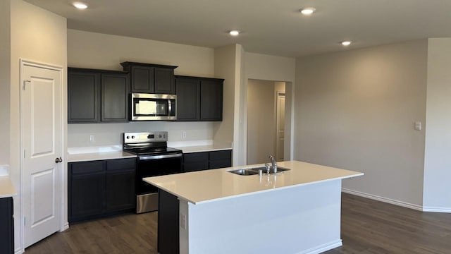 kitchen featuring stainless steel appliances, an island with sink, a sink, and light countertops