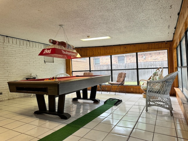 playroom with wood walls, light tile patterned flooring, a textured ceiling, and billiards