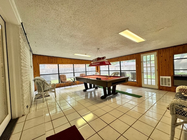 game room with wood walls and light tile patterned flooring