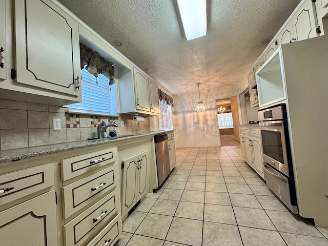 kitchen featuring appliances with stainless steel finishes, a healthy amount of sunlight, and light tile patterned flooring