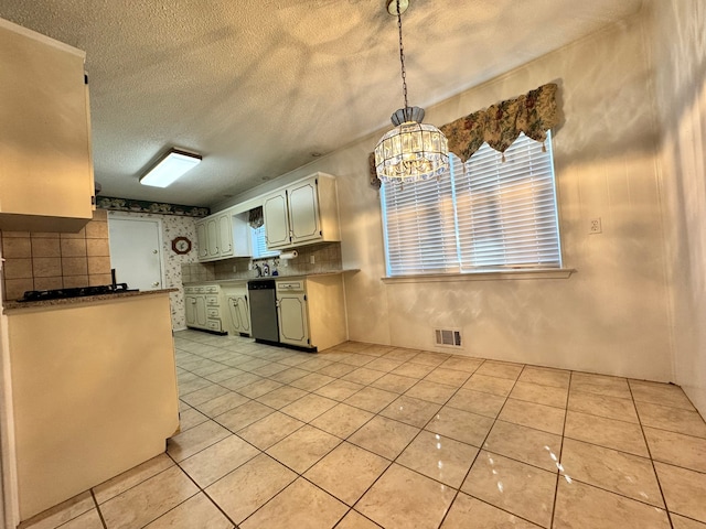 kitchen with dishwasher, light tile patterned floors, a textured ceiling, and decorative light fixtures