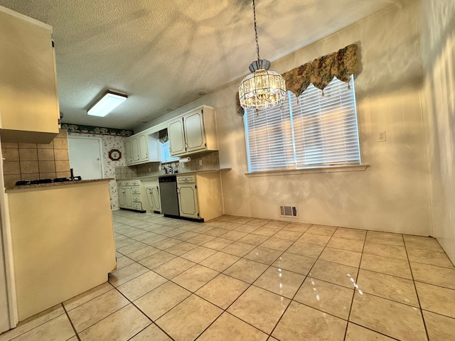 kitchen with stainless steel dishwasher, light tile patterned floors, hanging light fixtures, and a textured ceiling