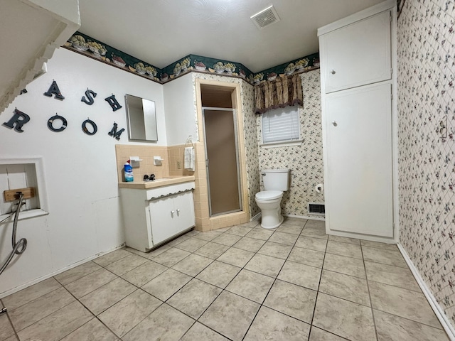 bathroom featuring tile patterned floors, vanity, toilet, and an enclosed shower