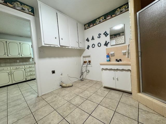 laundry room with electric dryer hookup and light tile patterned floors