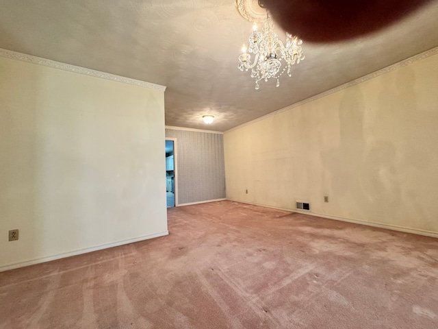 spare room featuring carpet, an inviting chandelier, and ornamental molding